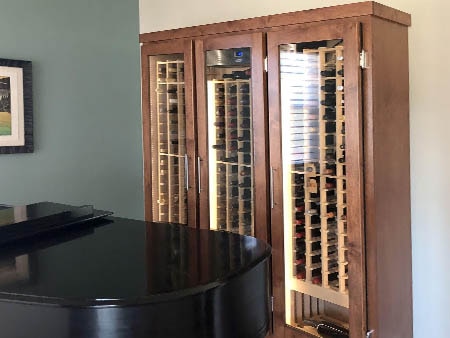 Custom wine cabinet in a corner behind a piano.