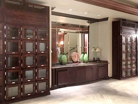Rows of stacked wood wine lockers, matching the wood of a country club room.