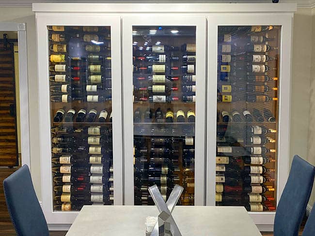 Contemporary white wine cabinet with lit interior and glass doors.