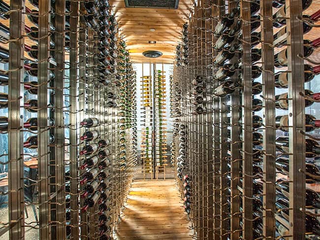 Spectacular glass enclosed custom wine cellar with metal wine racks.