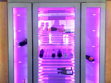 Glass front wine cabinet with vibrant modern lighting.