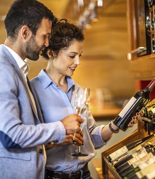 Couple in a wine cellar discussing which wine to choose